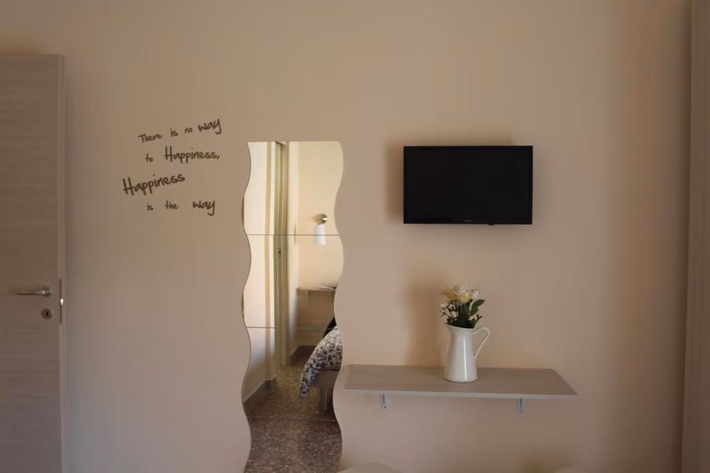 Stanza con TV a parete e composizione floreale
